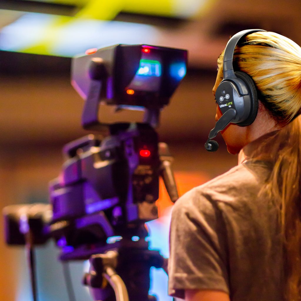 Girl operating camera while wearing ultralite headset.