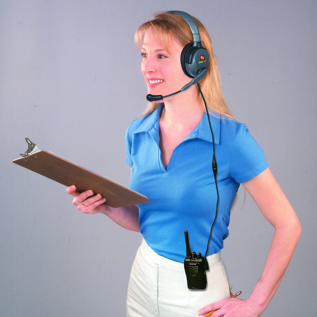 pretty blonde wearing Max 4G headset, holding clipboard.